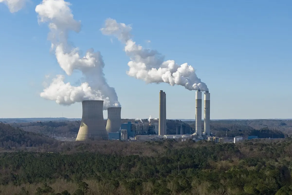 Cooling towers and smokestacks of a large coal-fired power plant in Alabama under a blue sky