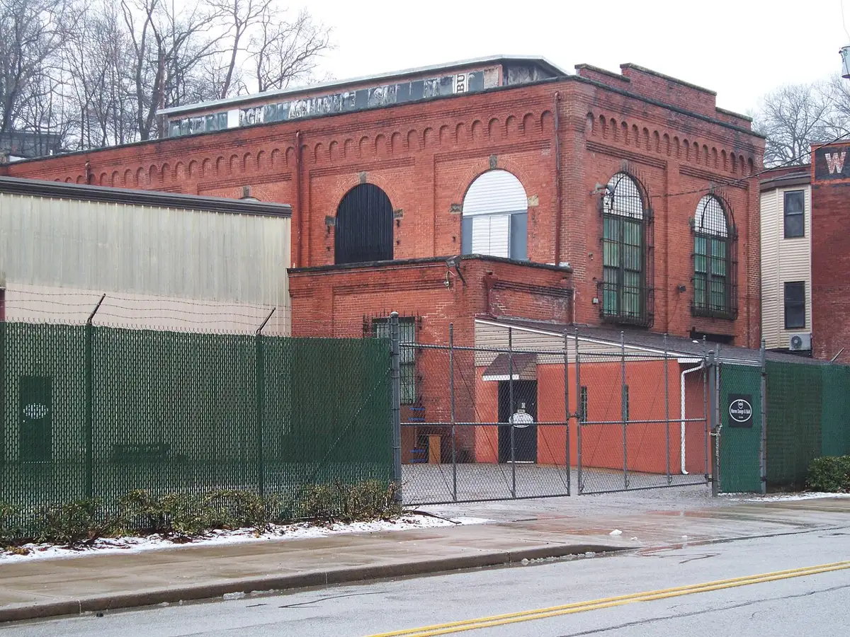 Brick Duquesne Light substation building behind a fence in a Pittsburgh neighborhood