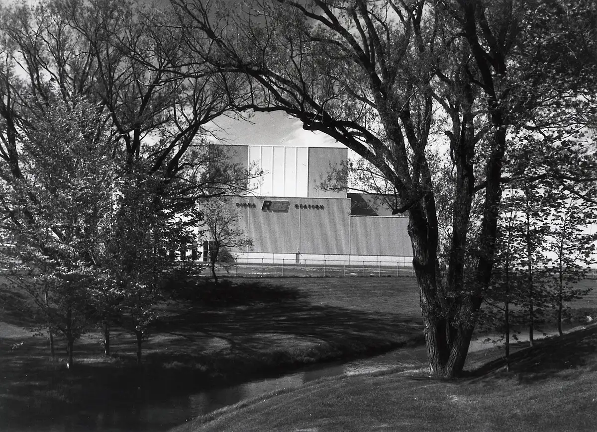 Black-and-white view of the Ginna station building marked RG&E, seen through trees