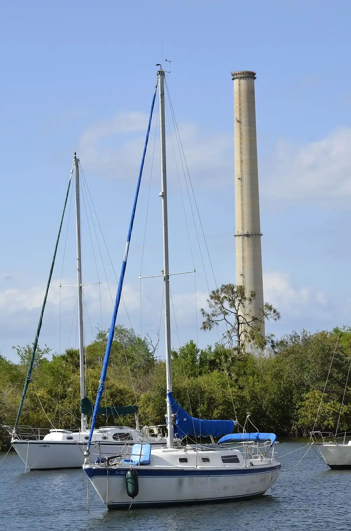 Image of electric power plant stack in background of sailboats moored @ Anclote River Park, Pasco County, Florida